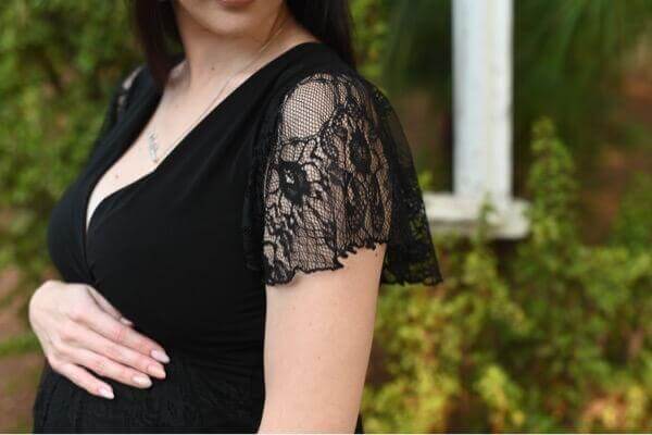 Black lace maternity dress with fitted bodice and frilly lace sleeves