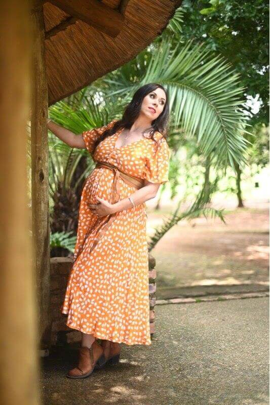 Mustard and white polka dot maternity and nursing dress with button-up front, short sleeves, and three-quarter length silhouette