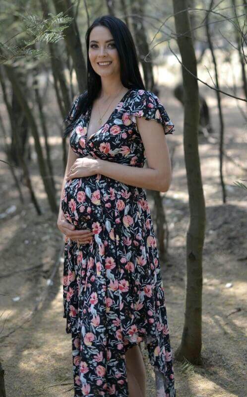 Black floral maternity and nursing dress with fold-over bodice, frilly sleeves, and pointy skirt