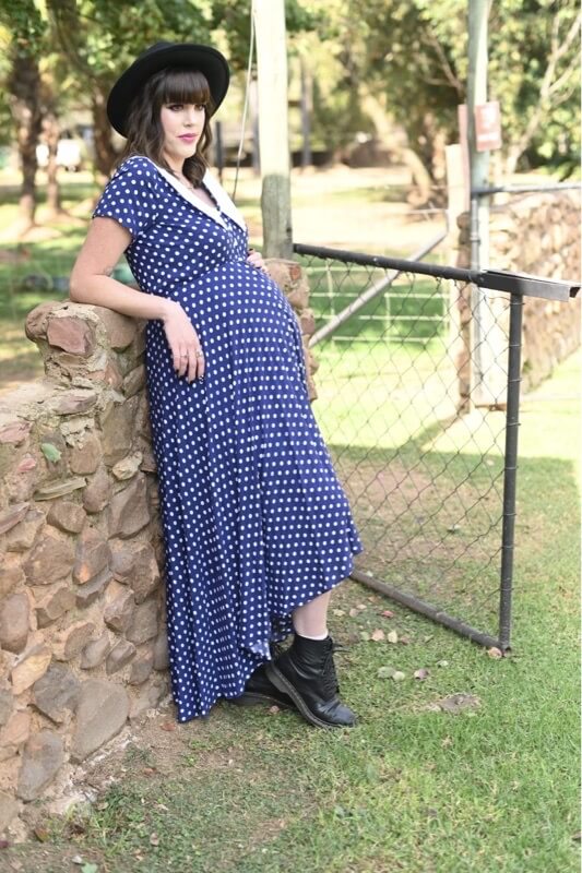 Navy and white polka dot maternity and nursing dress with Peter Pan collar, short sleeves, and hi-low silhouette