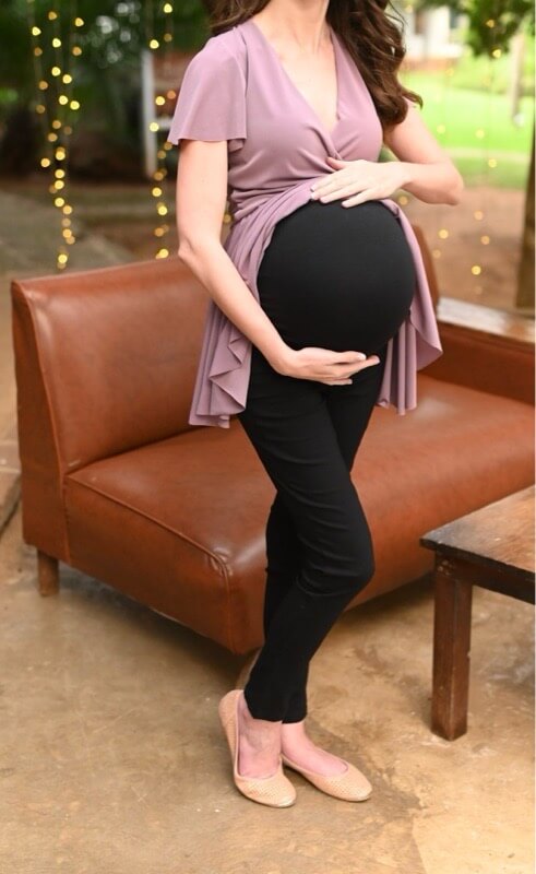 Pregnant woman wearing black skinny maternity pants with stretchy belly band