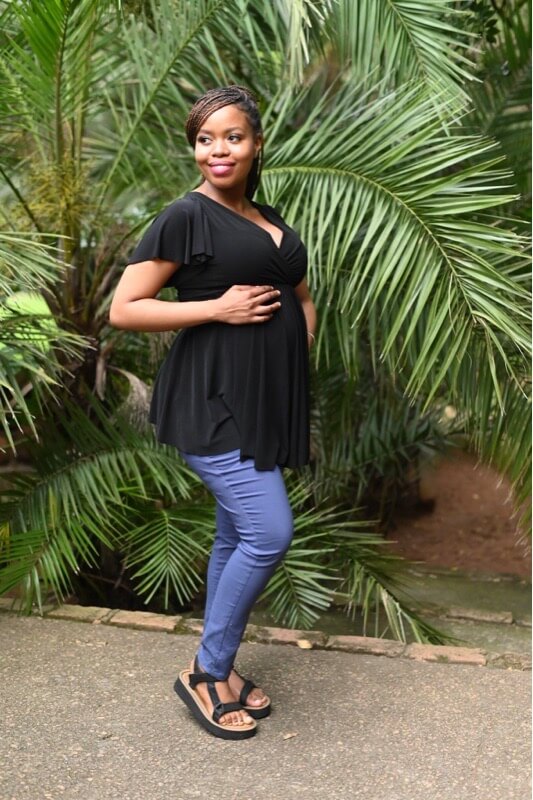 Pregnant woman wearing denim blue skinny maternity pants with stretchy belly band