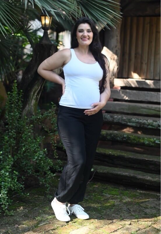 Pregnant model wearing black straight leg maternity viscose pants with stretchy belly band