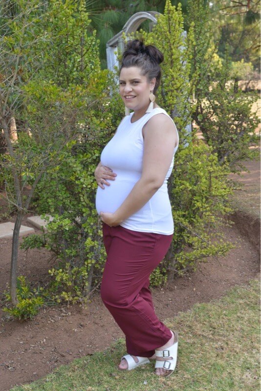 Pregnant model wearing burgundy straight leg maternity viscose pants with stretchy belly band