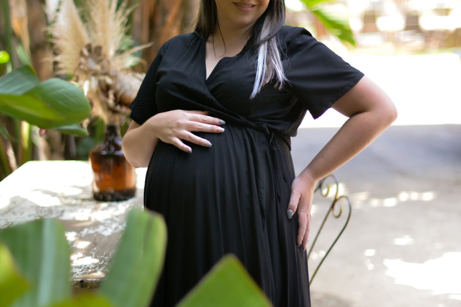Pregnant woman wearing black wrap maternity nursing dress in soft viscose fabric