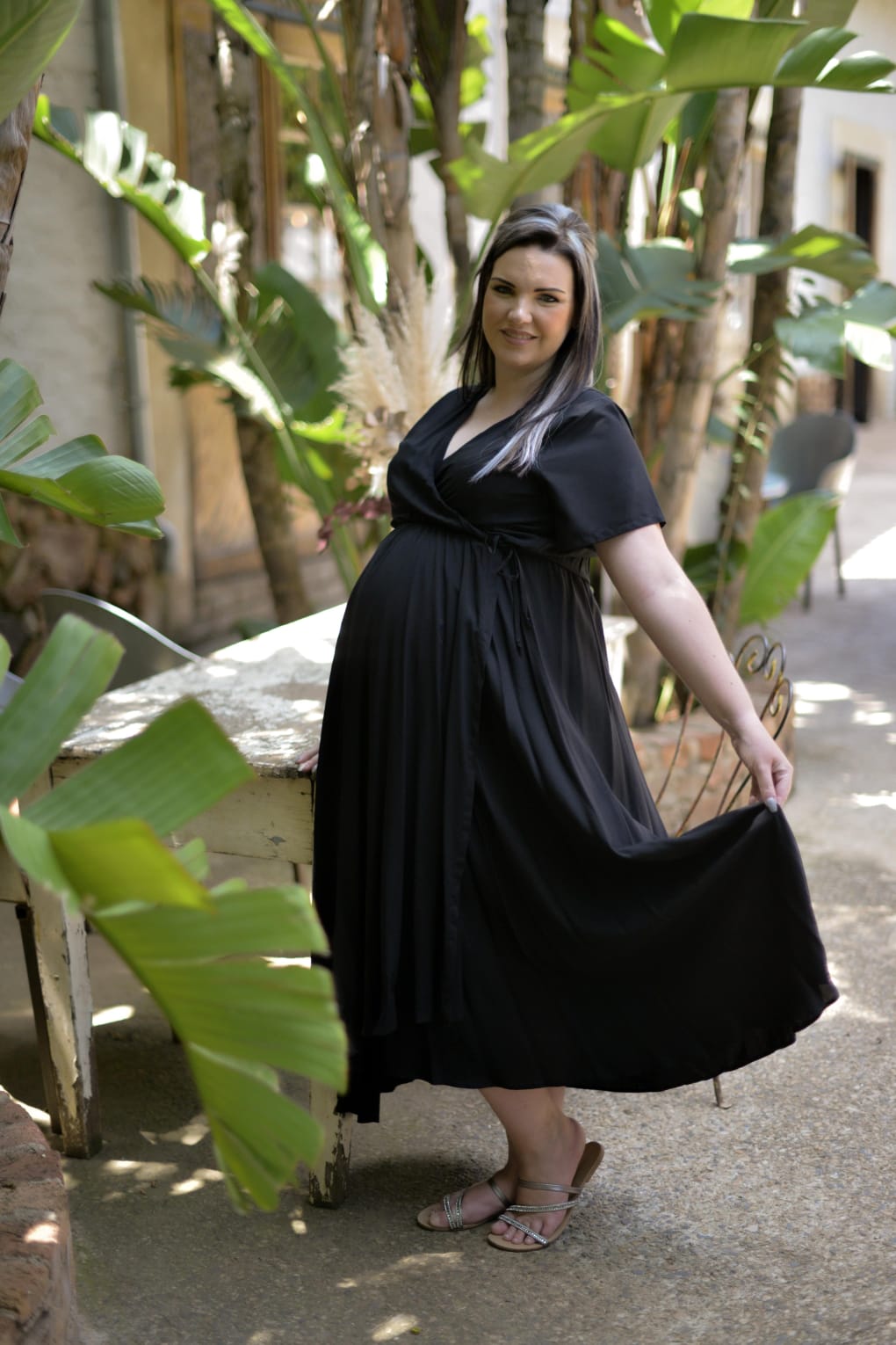 Pregnant woman wearing black wrap maternity nursing dress in soft viscose fabric