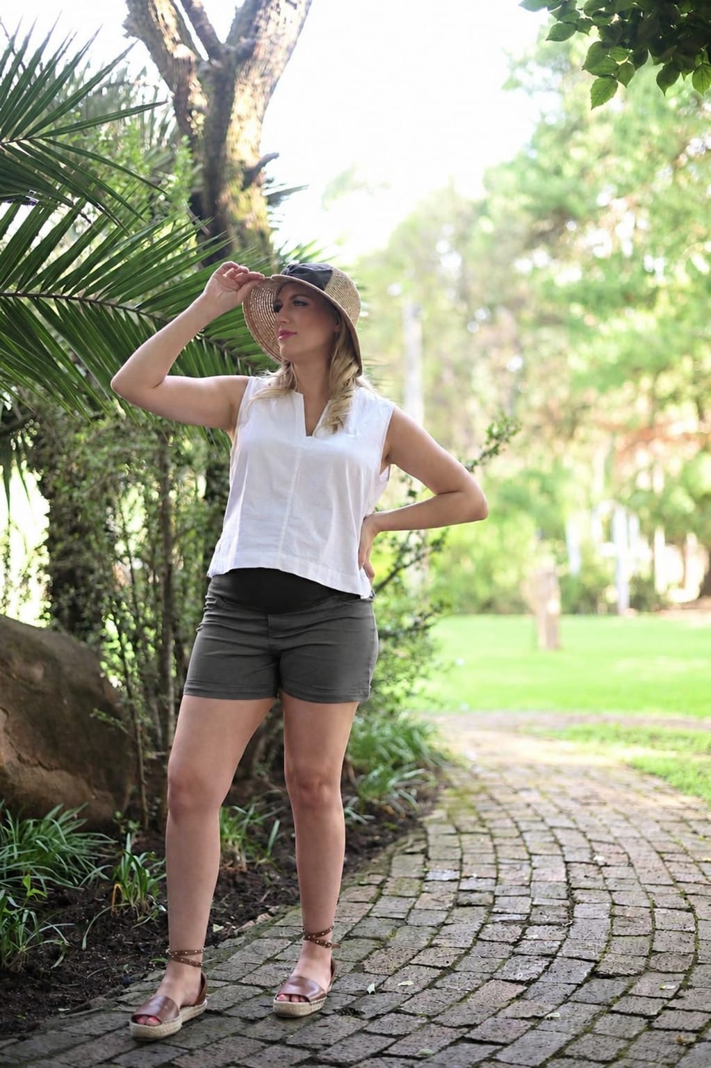 Pregnant model wearing grey maternity short shorts with stretchy belly band