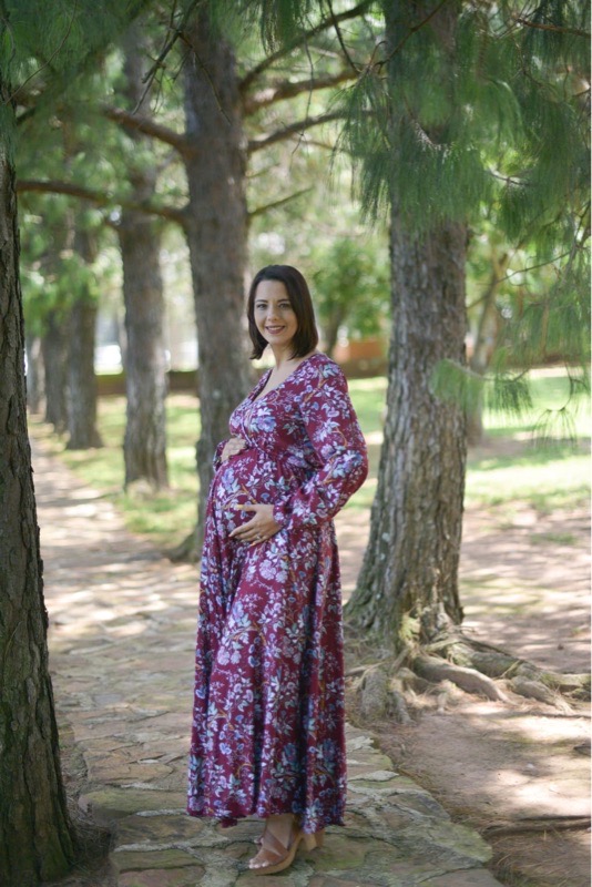 Pregnant woman wearing maroon floral fold-over maternity nursing dress