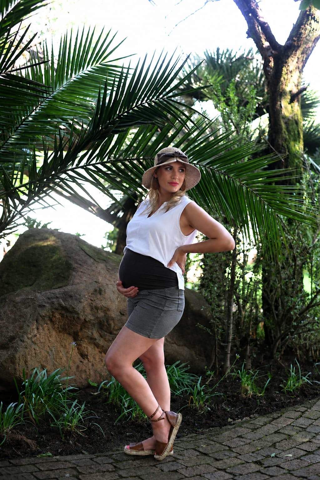 Pregnant model wearing grey maternity short shorts with stretchy belly band